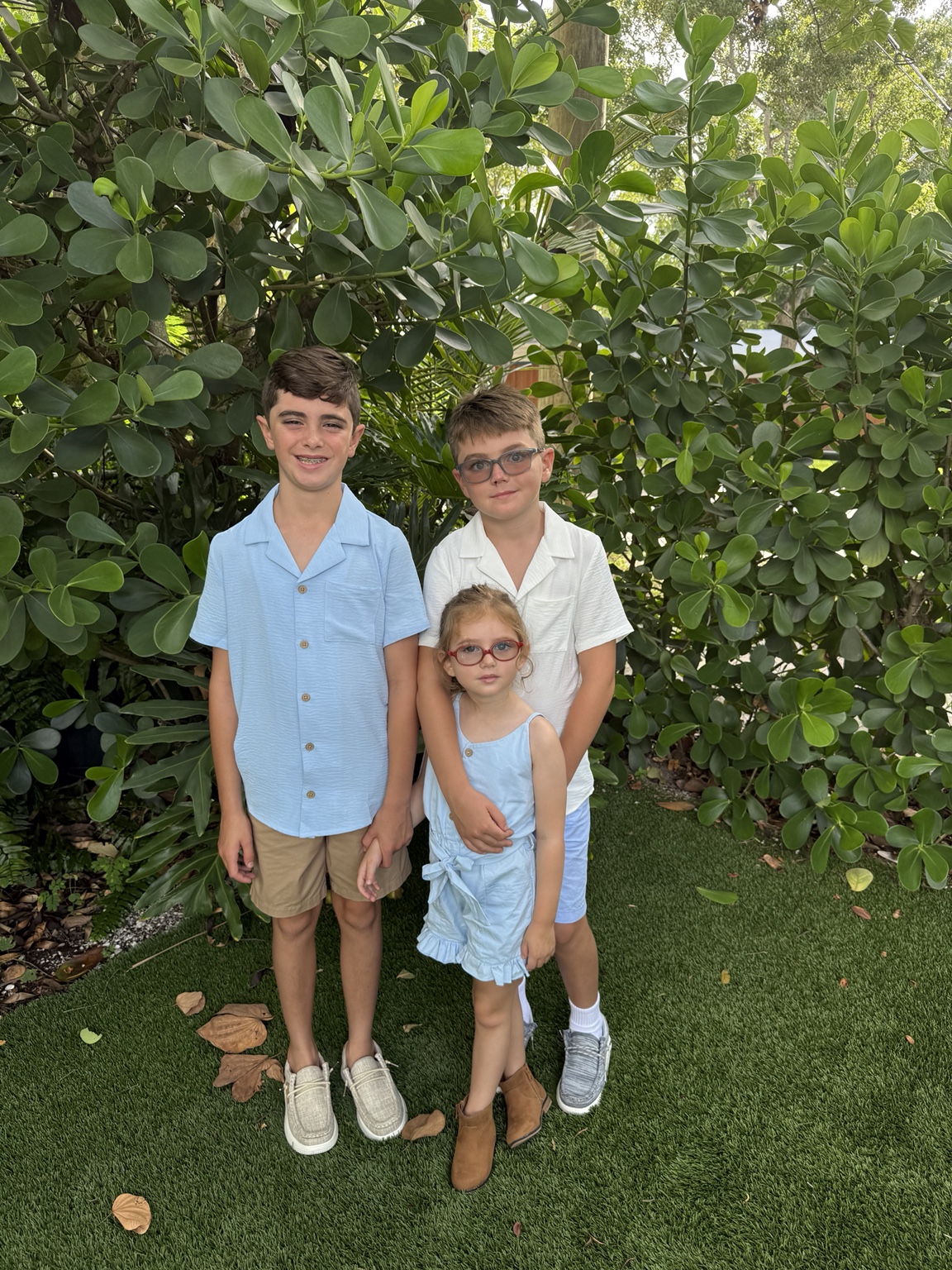 Lizzie standing with her two older brothers